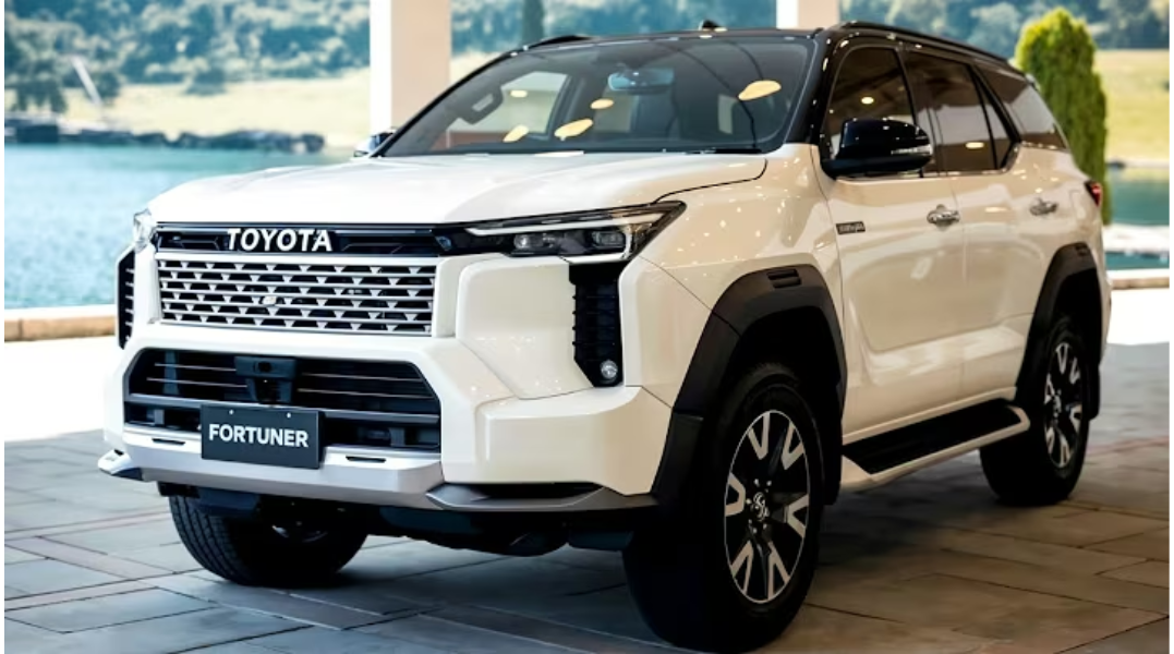 Front three-quarter view of the 2026 Toyota Fortuner GR-S top model in black color featuring sporty GR styling, LED headlights, large alloy wheels, muscular body design, and premium SUV stance on a highway road.